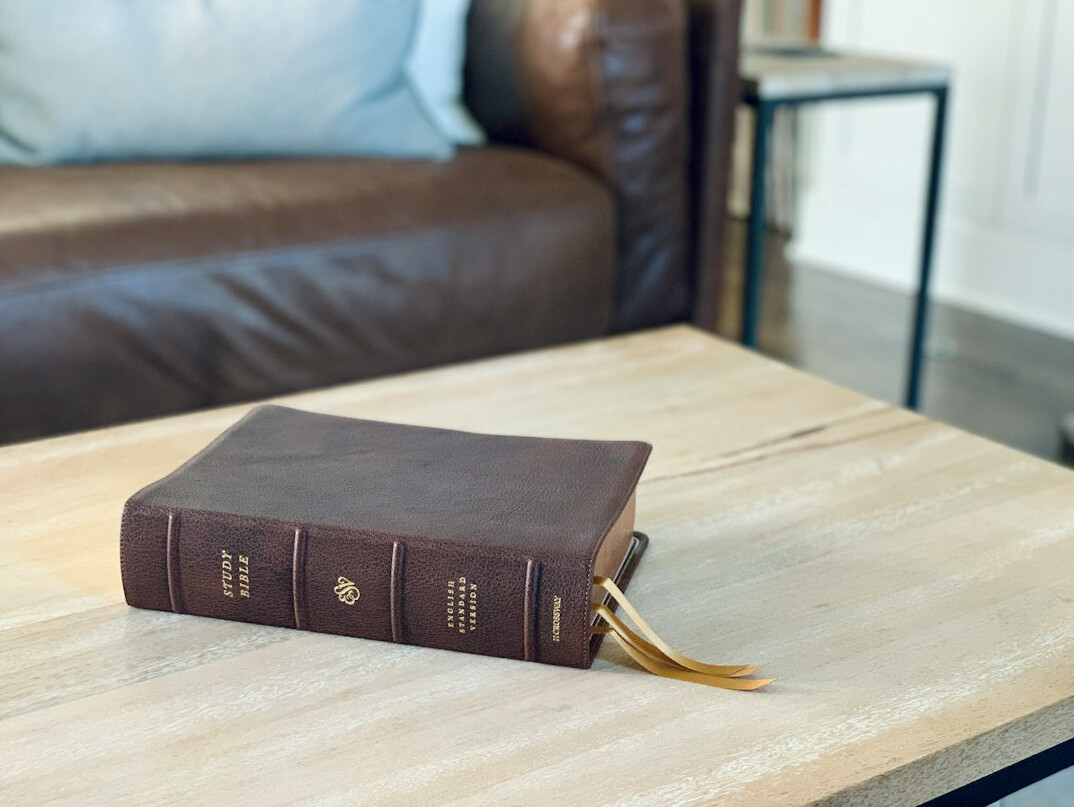 Stack of old leather-bound books on a wooden table